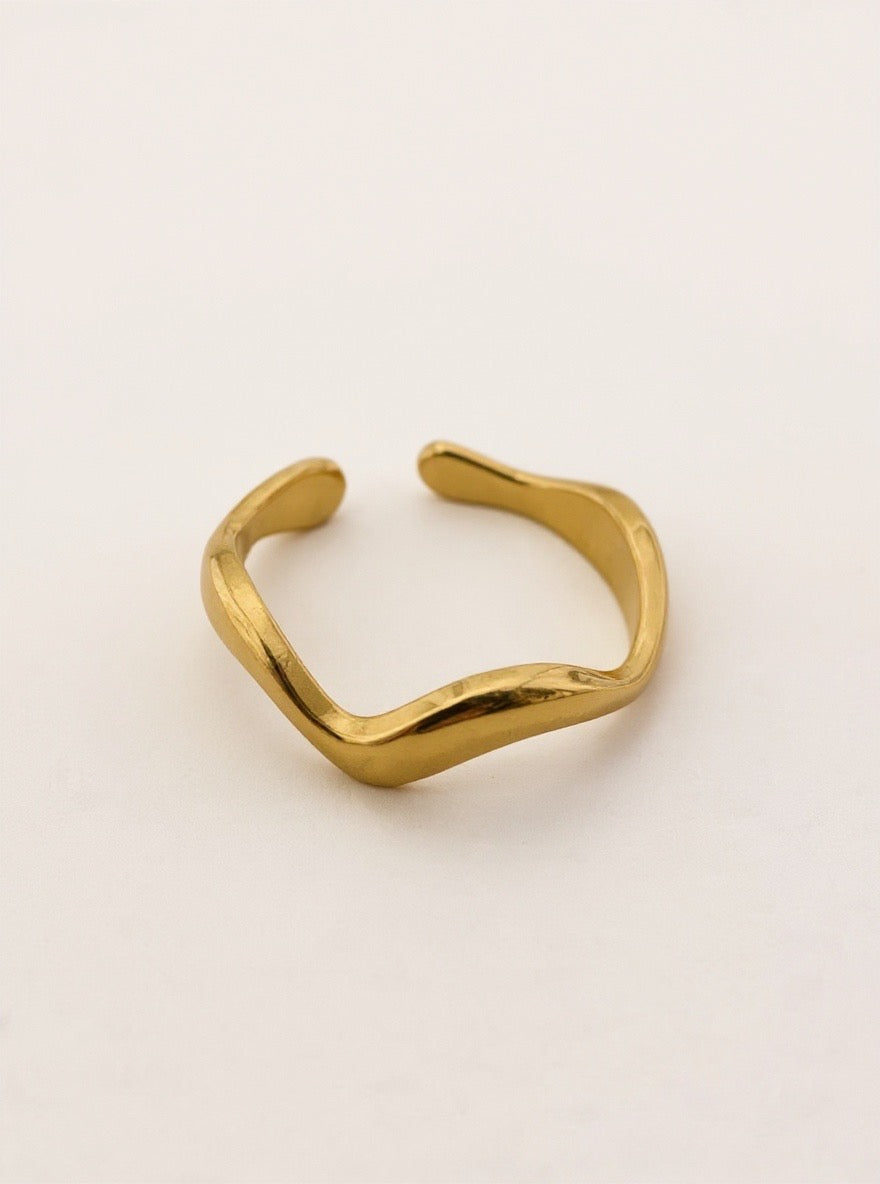 Gold open ring on a light beige background